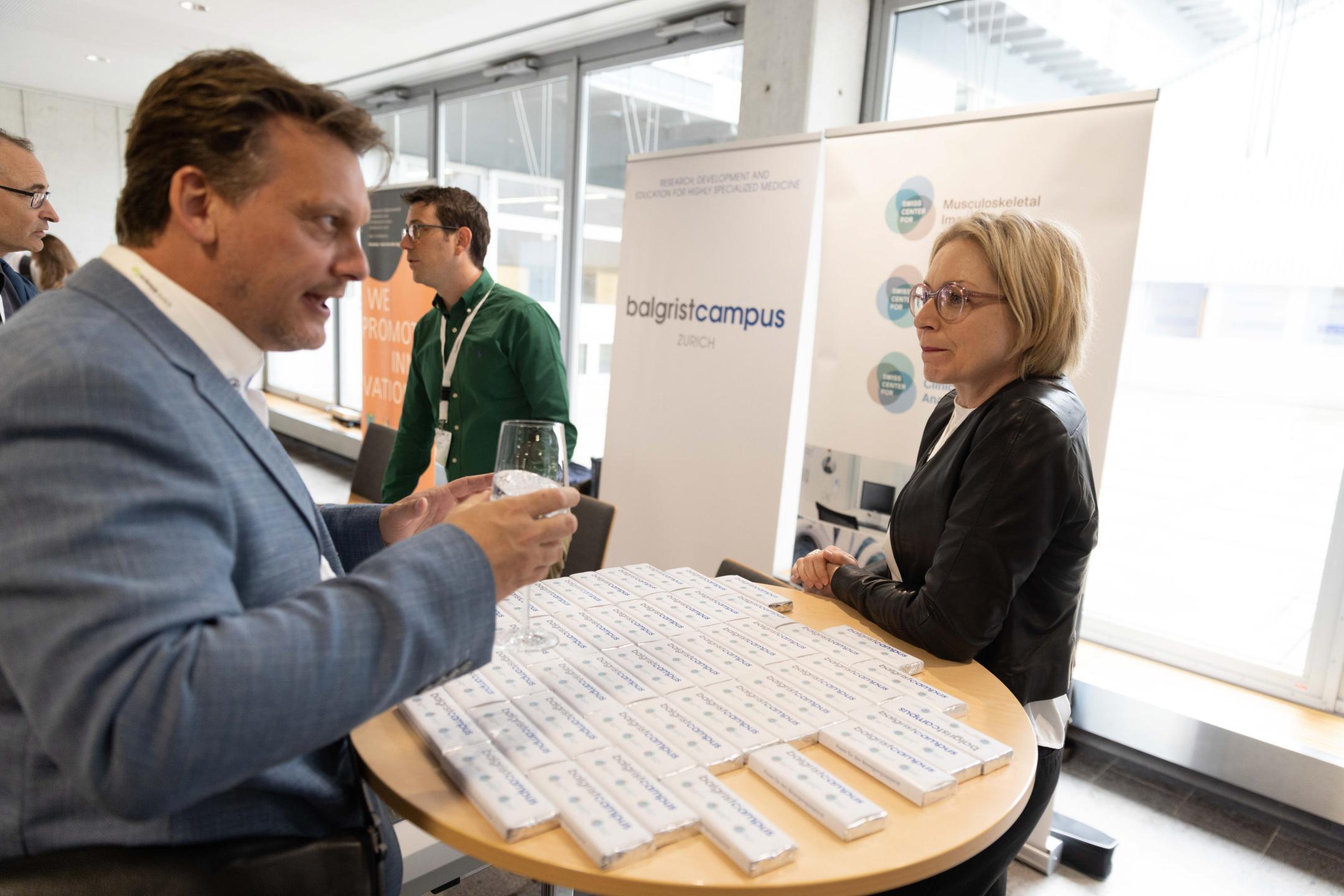 Ein Konferenzteilnehmer besucht den Stand des Balgrist Campus  an der Life Science Zurich Impact Conference 2023