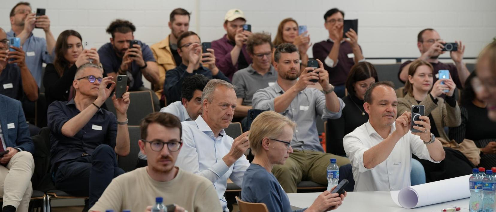 Teilnehmer beim Praxis -Seminar «Innovation-Sandbox für Künstliche Intelligenz» fotografieren einen QR-Code