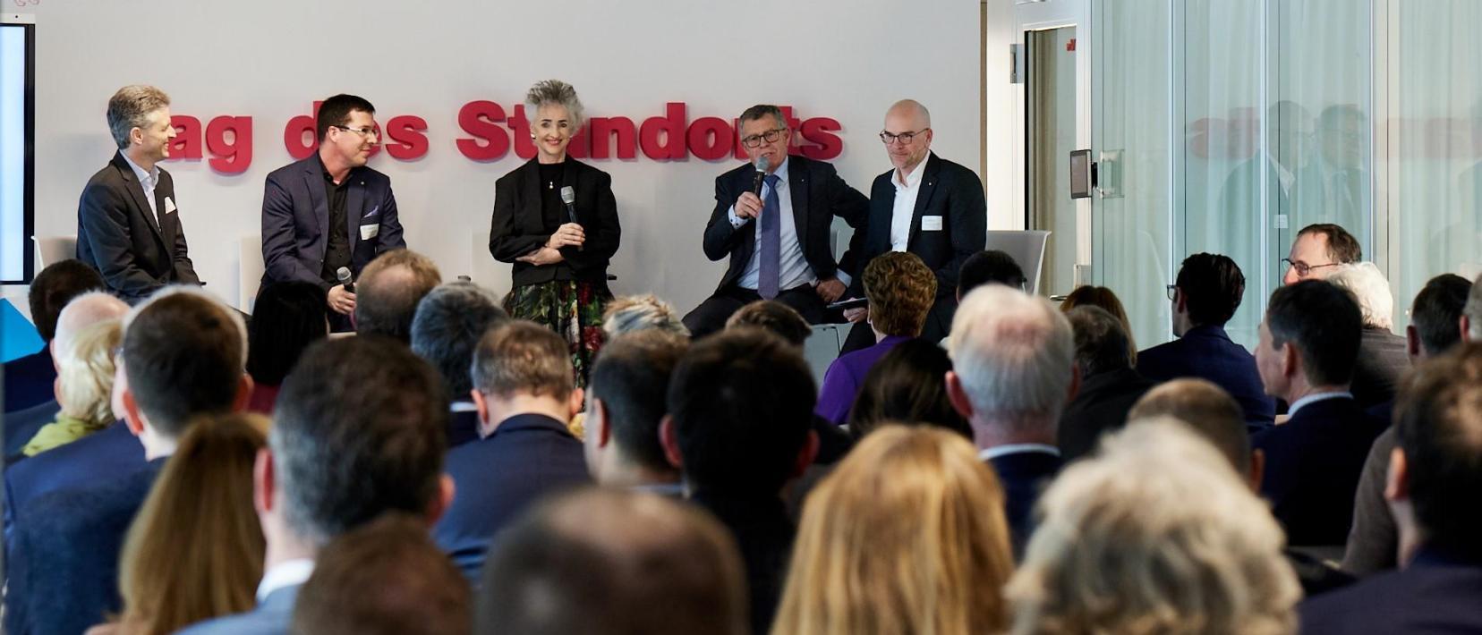 Zuhörende lauschen den Erklärungen von Podiumsteilnehmenden