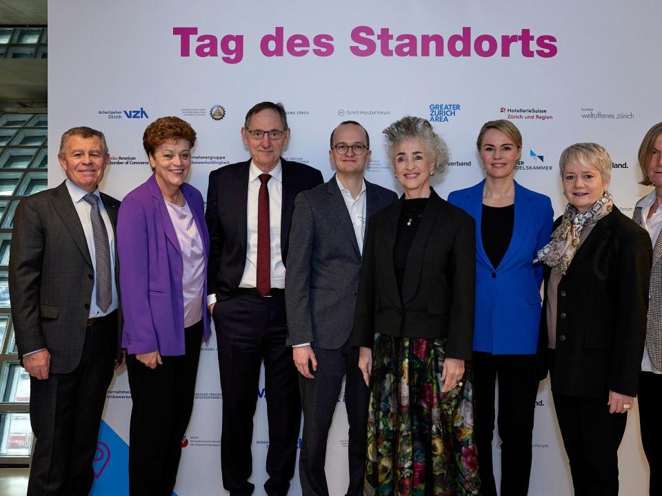Der gesamte Zürcher Regierungsrat steht vor einer Tafel, auf der «Tag des Standorts» steht