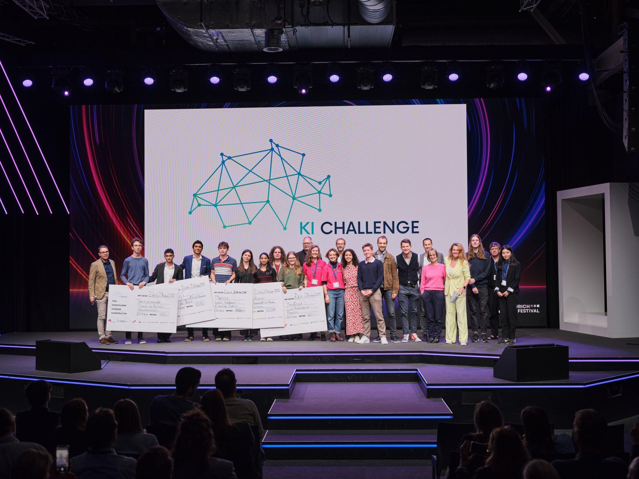 Eine grosse Gruppe von Jugendlichen, Jurorinnen und Juroren steht auf der Bühne des Zurich AI Festivals vor dem Logo der KI Challenge und hält symbolische Schecks.
