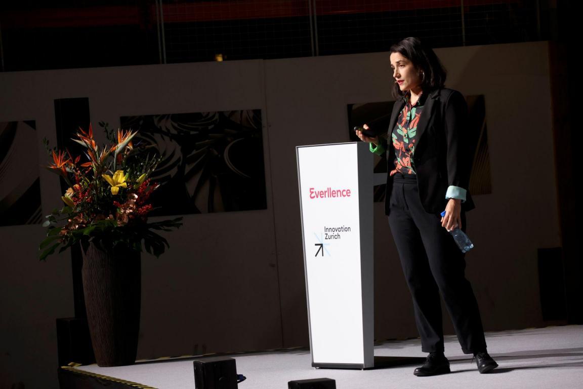 Anastasia Stamatiou präsentiert auf der Bühne neben einem Everllence-Pult und Blumenarrangement bei «Industrie im Dialog».