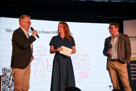 Roger Bachmann, Stadtpräsident von Dietikon, und Markus Müller, Co-Leiter der Standortförderung des Kantons Zürich, stehen gemeinsam mit der Moderatorin Kathrin Hönegger auf der Bühne.