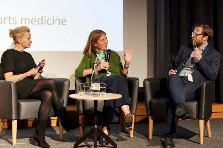 Prof. Beatrice Beck Schimmer spricht in das Mikrofon und sitzt zwischen der Moderatorin Dr. Anna Erat, links, und Prof. Thomas Ott auf der grossen Bühne. 