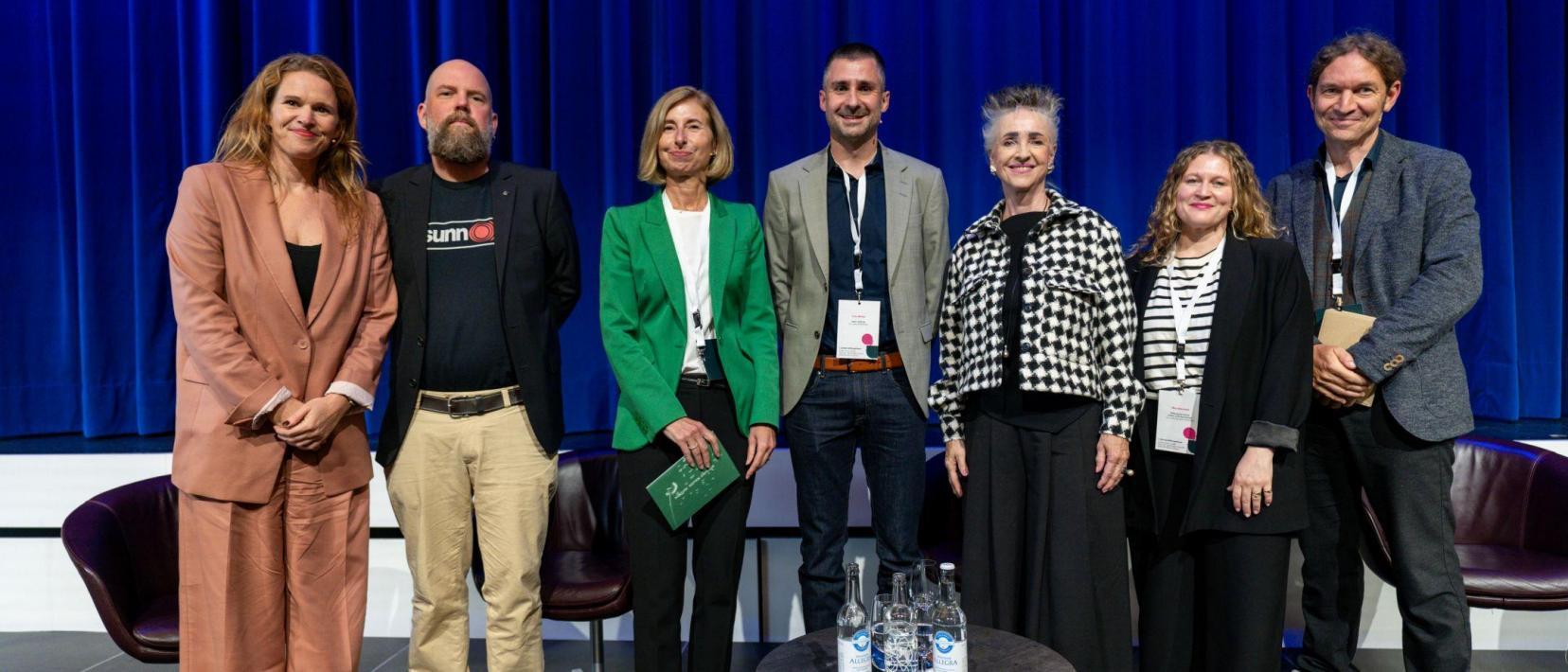 Gruppenfoto der Podiumsgäste und Moderatorin am 1. Zürcher Stiftungsforum 2025 zum internationalen Tag der Stiftungen. Auf der Bühne stehen sieben Personen nebeneinander und blicken in die Kamera.