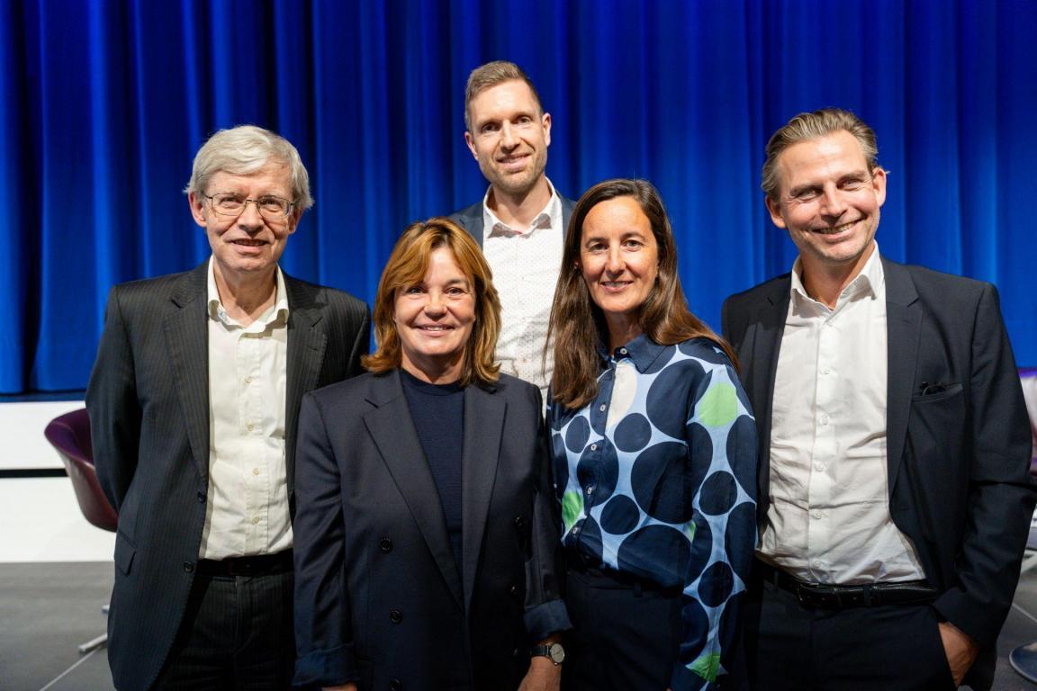 Gruppenfoto des Vorstands des Vereins Stiftungsstandort Kanton Zürich am 1. Zürcher Stiftungsforum. Fünf Vorstandsmitglieder stehen auf der Bühne vor blauem Vorhang und blicken in die Kamera.
