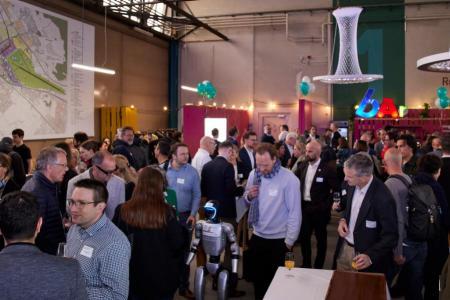 Eine grosse Gruppe von Teilnehmenden tauscht sich untereinander aus