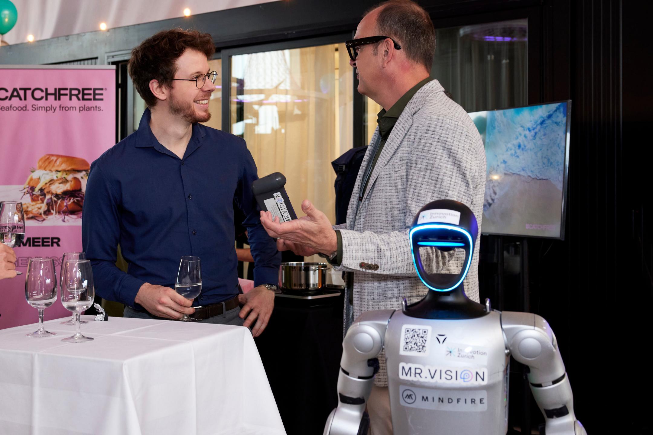 René Vogel erklärt einem Gast seinen humanoiden Roboter 