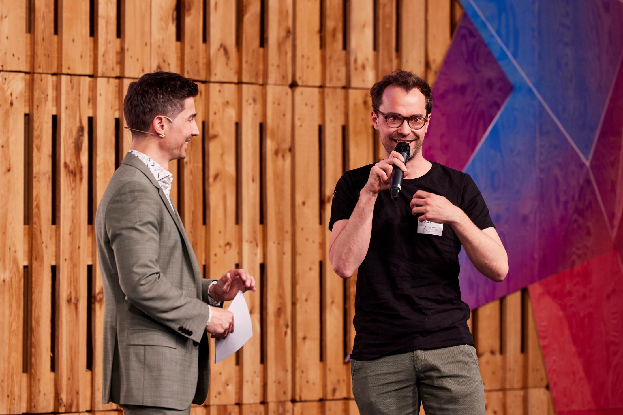 Moderator Tobias Müller und Co-Leitung der Standortförderung Samuel Mösle auf der Bühne