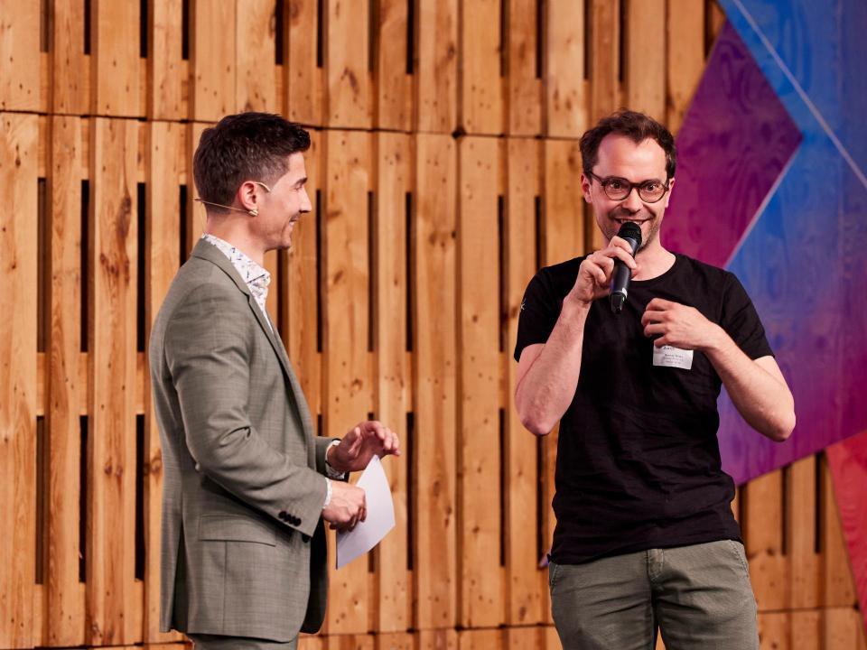 Moderator Tobias Müller und Co-Leitung der Standortförderung Samuel Mösle auf der Bühne