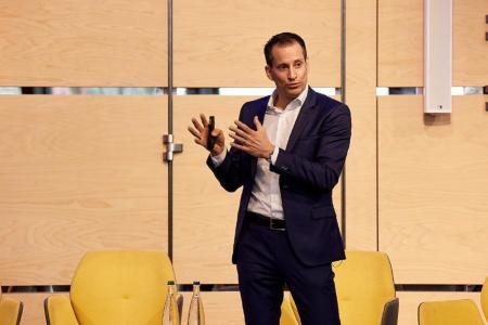 Fabian Streiff, Amtschef des Amts für Wirtschaft, gestikuliert während eines Vortrags auf der Bühne und erläutert wirtschaftliche Zusammenhänge.