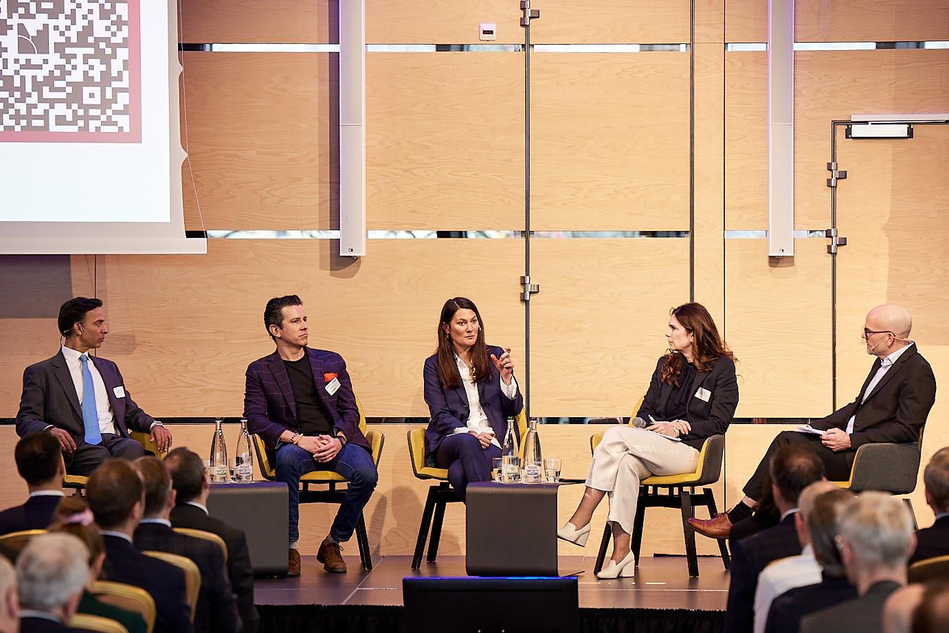 Podiumsdiskussion zum Thema globaler Wettbewerb und lokale Akzeptanz vor Publikum.