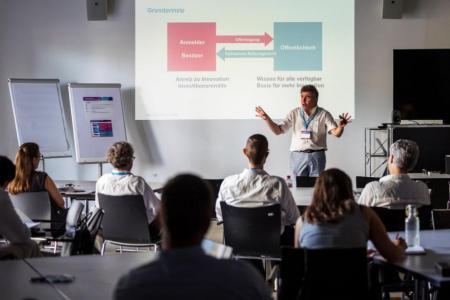 Teilnehmende hören dem Vortrag zum Thema Competitive Intelligence zu 