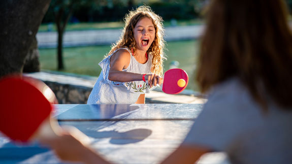 L&auml;chelndes M&auml;dchen spielt Tischtennis