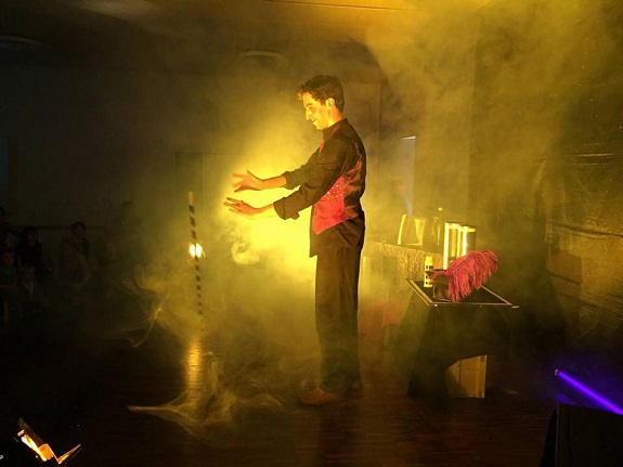 Ein Zauberer auf der Bühne, von Licht und Nebel umhüllt