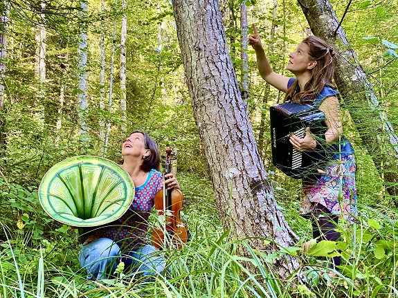 Zwei Frauen mit Akkordeon und Geige im Wald