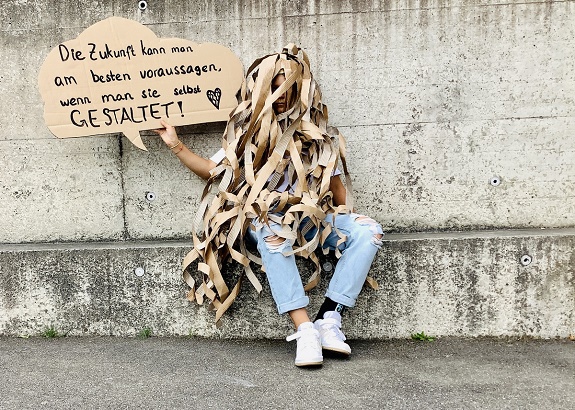 Verkleidete Person h&auml;lt ein Schild: Die Zukunft kann man am besten voraussagen, wenn man sie selbst gestaltet.