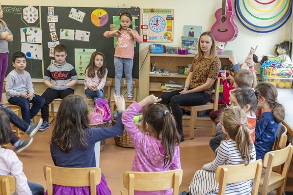 Kindergartensch&uuml;ler und -sch&uuml;lerinnen sitzen im Kreis