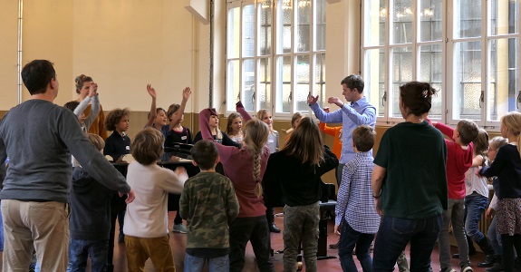 Sch&uuml;lerinnen und Sch&uuml;ler w&auml;hrend einer Singprobe mit ihrem Dirigenten