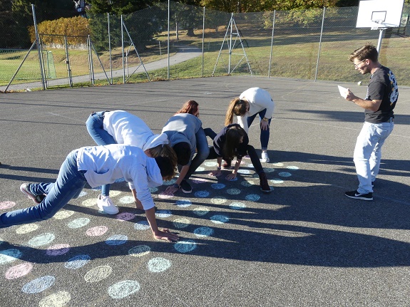 Jugendliche spielen auf dem Asphalt ein Spiel auf einem mit Kreide gezeichneten Spielfeld