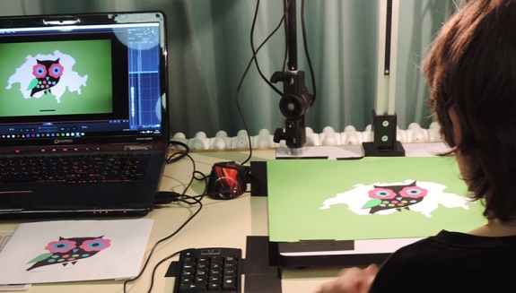 Junge mit Laptop und Zeichnung am Erstellen eines Trickfilms