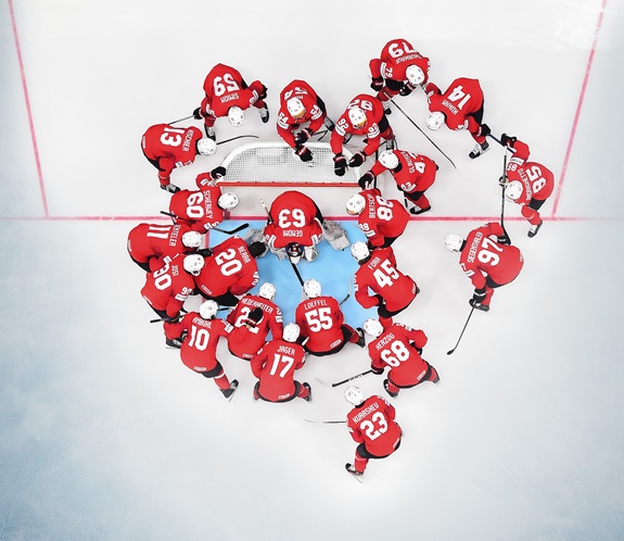 Eishockeymannschaft steht ums Tor - von oben fotografiert.