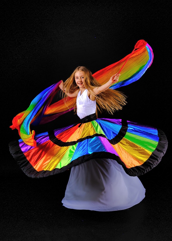 M&auml;dchen in einem weiten, farbigen Kleid, das sie wie einen Surli aussehen l&auml;sst.