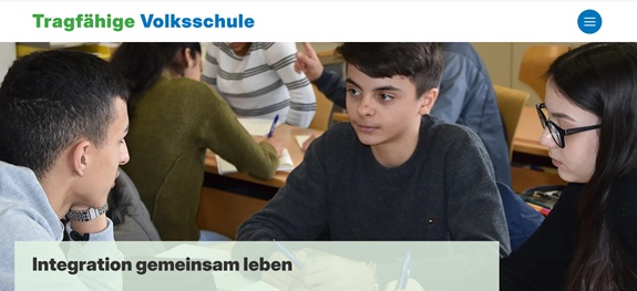 Jugendliche arbeiten gemeinsam an einem Tisch in einem Klassenraum; dar&uuml;ber der Schriftzug &laquo;Tragf&auml;hige Volksschule&raquo; und &laquo;Integration gemeinsam leben&raquo;. 