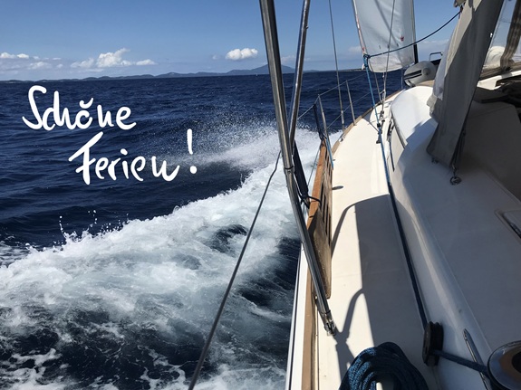 Segelboot auf offenem Meer mit Gischt und dem Schriftzug &laquo;Sch&ouml;ne Ferien!&raquo;.
