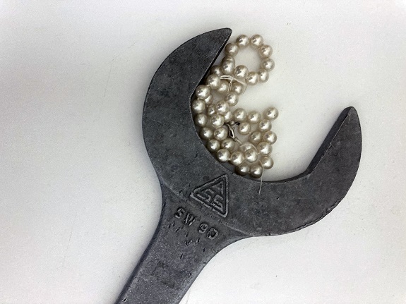 Eine Perlenkette in der Rundung eines Schraubenschlüssels