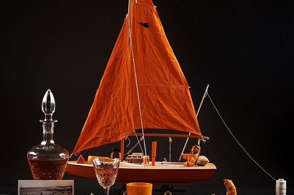 Schiff mit orangem Segel und weiteren orangen Gegenständen