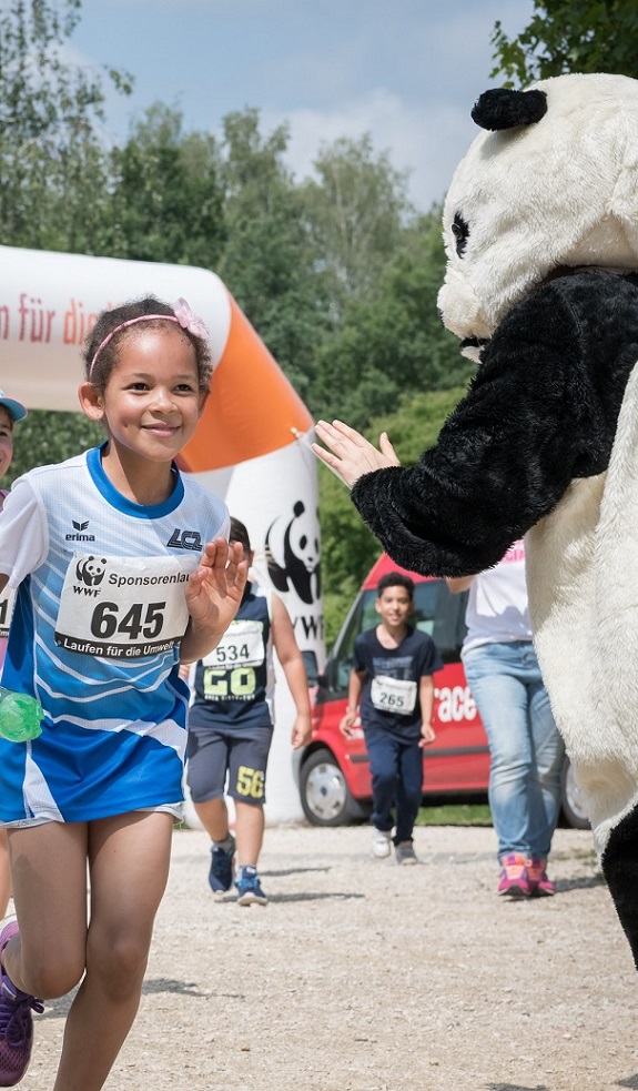 Junge Läuferin und als Panda verkleidete Person
