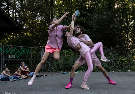 Junge Menschen in rosa Sportbekleidung ringen um einen ballähnlichen Gegenstand